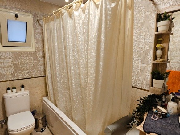 Cozy bathroom with shower curtain.